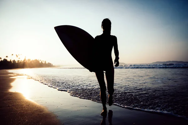 冲浪者在日出时在海滩上与冲浪板散步 — 图库照片