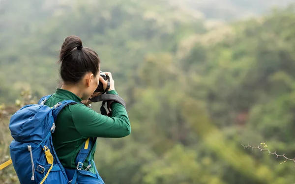 春の森の山で写真を撮る女性写真家 — ストック写真