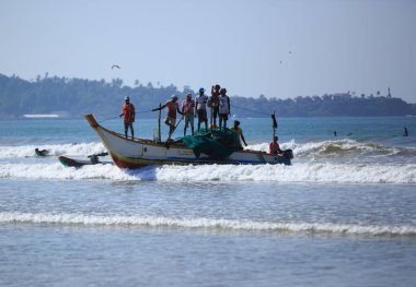 Weligama, Sri Lanka - 23 Şubat 2019: Sri Lanka'nın geleneksel balıkçı teknesi deniz suyuna yelken açıyor.