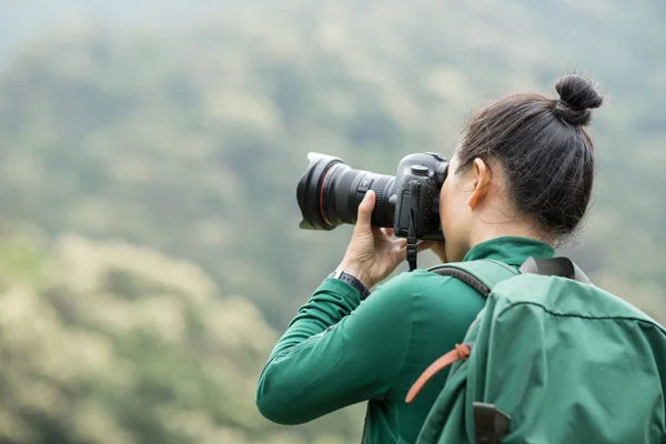 春の森の山で写真を撮る女性写真家 — ストック写真