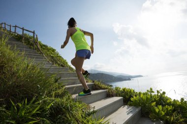 Kararlı kadın sahil dağ merdivenlerde koşma