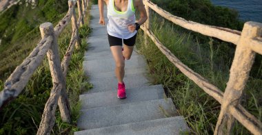 Kararlı kadın sahil dağ merdivenlerde koşma