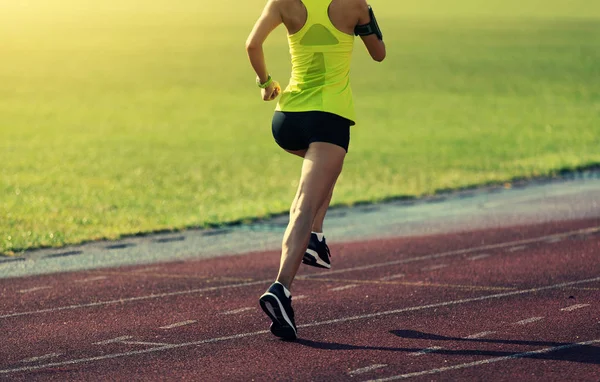 年轻的健身女人在体育场跑道上运行 — 图库照片