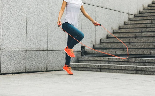 young fitness woman jumping on rope outdoor