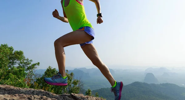 Successful woman running up on mountain top cliff edge