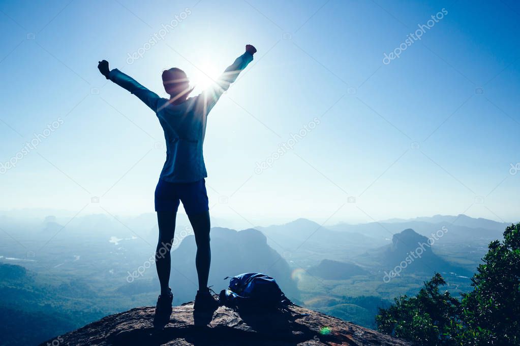 Successful woman hiker in the sunrise mountain top