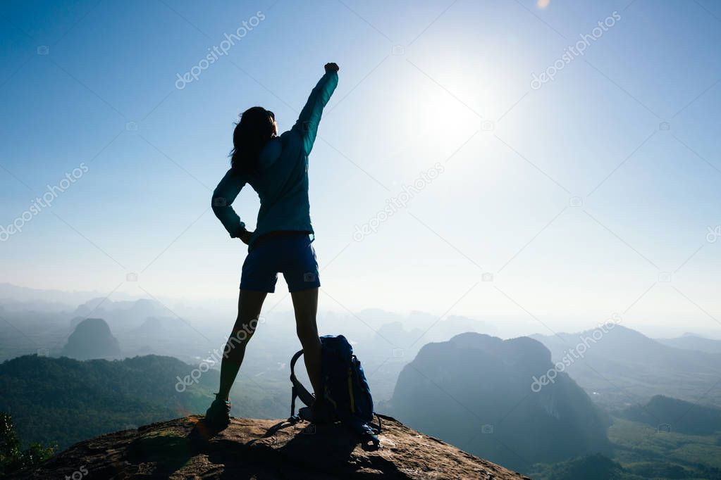 Successful woman hiker in the sunrise on mountain top