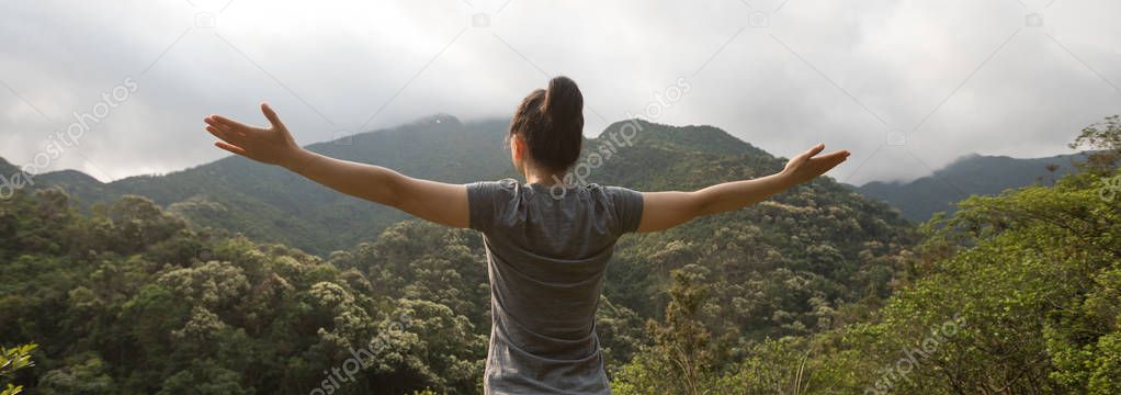 young woman feel free at forest on mountain top