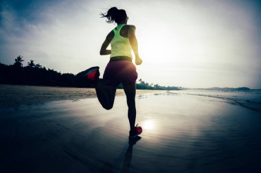 Gün doğumu plajda çalışan fitness kadın 