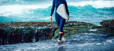 Sörf tahtası olan bir kadın sörf yapıyor.