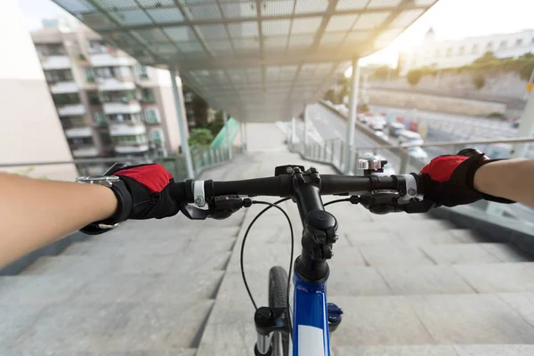 Riding bike down stairs of overpass in city