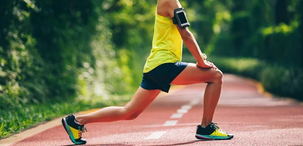朝の公園で足を伸ばす健康的なライフスタイルの女性ランナー — ストック写真