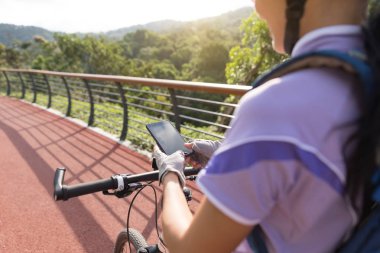 Bisikletçi bahar orman izi üzerinde bisiklet sürerken fotoğraf çekmek akıllı telefon kullanarak