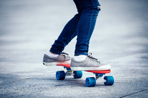 woman skateboarder legs skateboarding at city