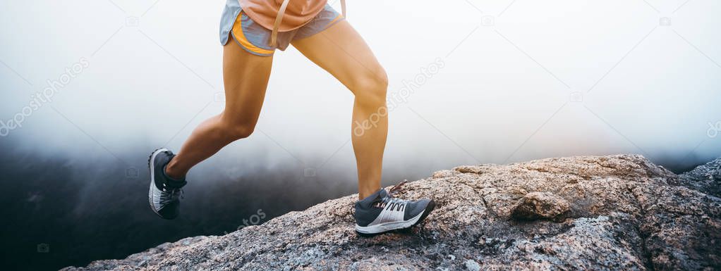 Young fitness woman running up to the mountain top