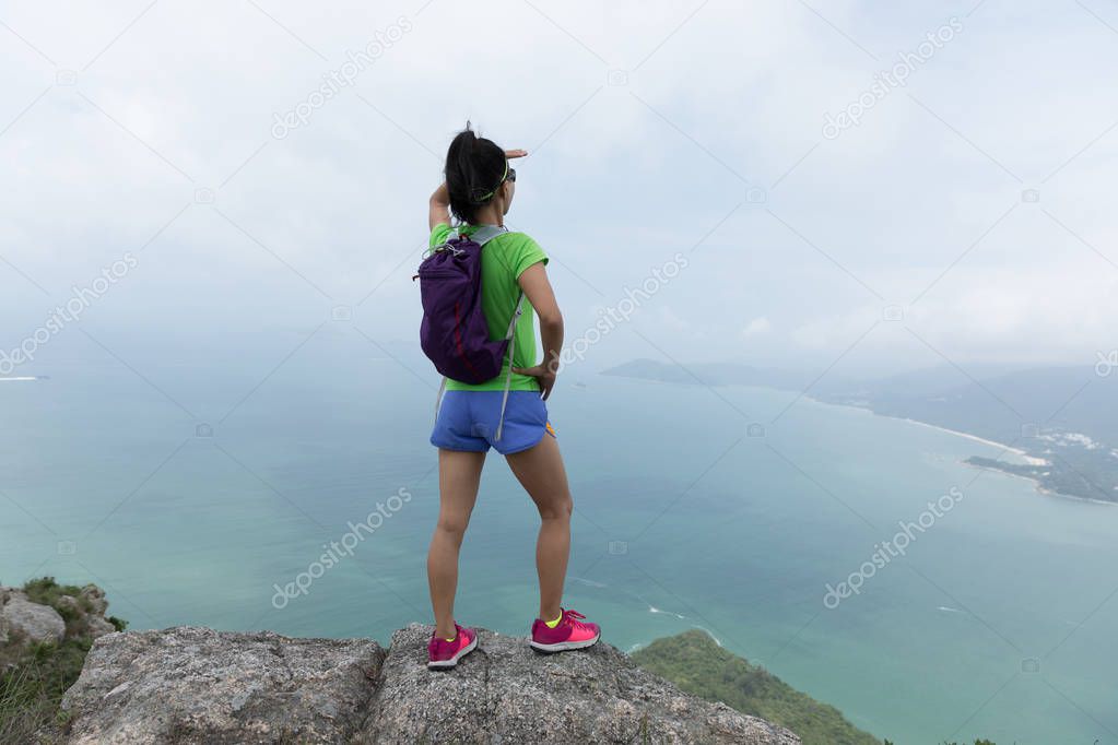Successful Woman Hiker enjoy the beautiful view on Mountain Top at Seaside