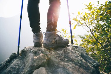 Dağ tepe kayalık kenarında başarılı yürüyüşçü bacaklar 