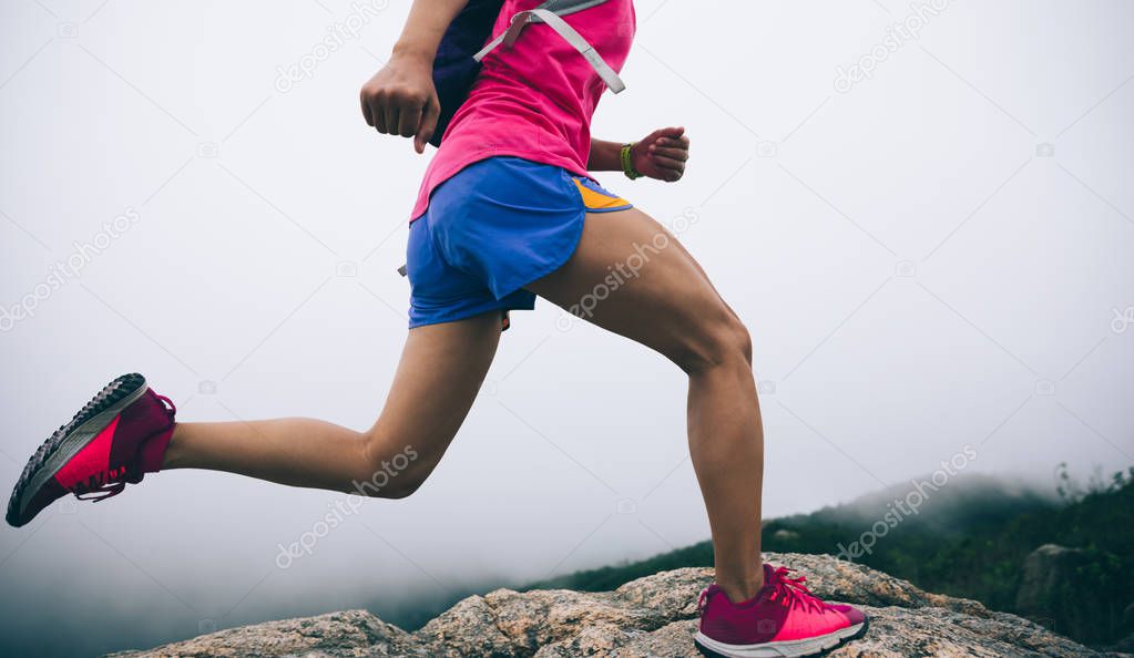Healthy lifestyle, woman ultra marathon runner running up to the seaside mountain top