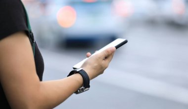 modern şehirde akıllı telefon kullanan kadın