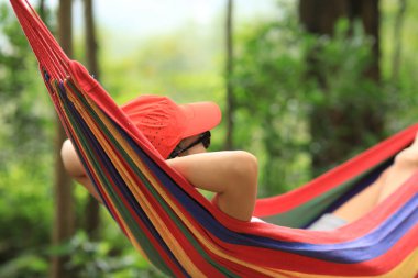 Yaz ormanında renkli hamakta dinlenen kadın