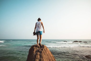 Deniz kenarında uçurumun kenarına yürüyen cesur kadın 
