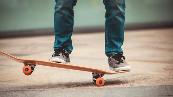 Skateboarder legs riding skateboard on city street