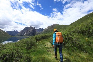 Yüksek irtifa dağlarda yürüyüş genç sırt çantalı kadın