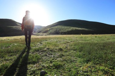 bir sırt çantasıyla kadın gündoğumu dağlarda hiking