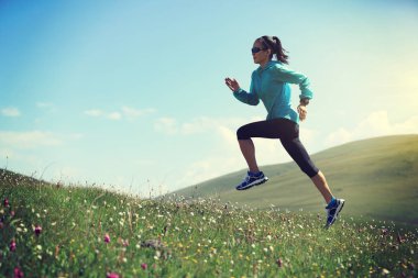 Otlakta koşan ultra maraton koşucusu bir kadın.