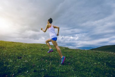 Otlakta koşan ultra maraton koşucusu bir kadın.