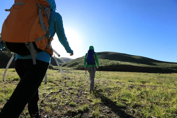 两个在日出山徒步旅行的背包妇女 — 图库照片