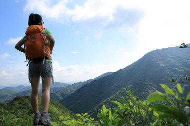 Genç kadın backpacker yaz dağ zirvesinde görünümü zevk 