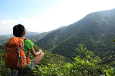 Başarılı genç kadın backpacker bahar orman dağ uçurumun kenarında görünümü keyfini çıkarın