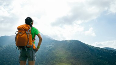 Başarılı kadın backpacker yaz dağ zirvesinde görünümü zevk 