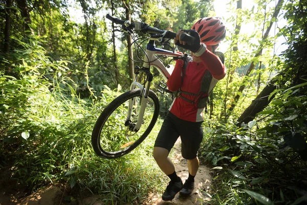 在热带森林上行走的骑自行车的妇女 — 图库照片