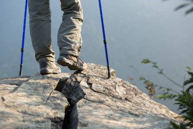 Başarılı kadın yürüyüşçü dağ tepe kaya üzerinde duran görünümü zevk