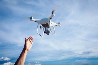Deniz üzerinde fotoğraf çeken uçan bir drone ulaşan el