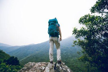 Başarılı kadın yürüyüşçü dağ tepe uçurumun kenarında görünümü zevk