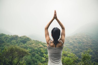 pratik Yoga sisli bahar dağ tepe üzerinde kadın