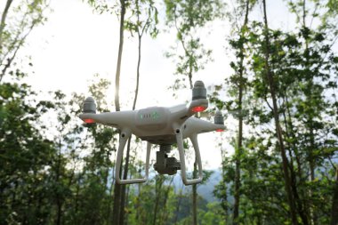 Tropikal ormanda uçan beyaz drone