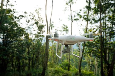 Tropikal ormanda uçan beyaz drone