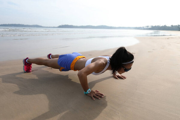Фитнес азиатская женщина делает отжимания на пляже, концепция здорового образа жизни
