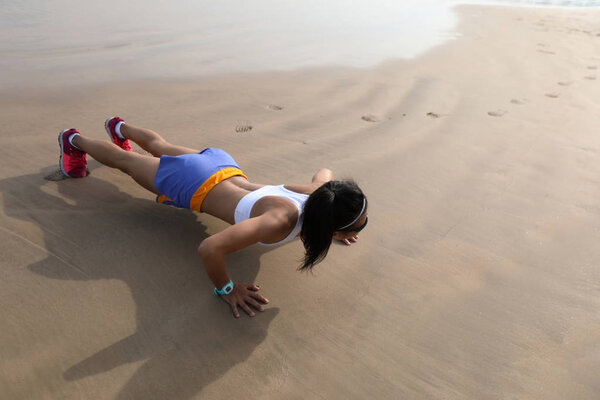 Фитнес азиатская женщина делает отжимания на пляже, концепция здорового образа жизни
.