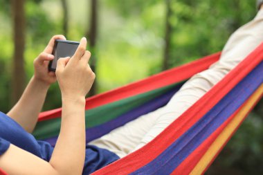 Yağmur ormanlarında akıllı telefon ile hamakta dinlendirici