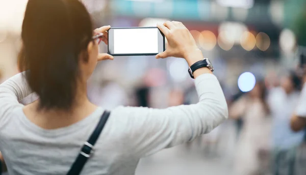 女性は街の通りで写真を撮るスマートフォンを使用します — ストック写真