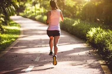 Yaz parkında koşan bir bayan koşucu. Sağlıklı kadın dışarıda koşuyor..  