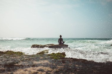 Sahil mercan uçurumun kenarında kadın uygulama yoga dalgalar yüz