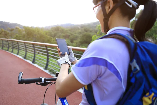 骑自行车使用智能手机拍照 而骑自行车在春天森林小径 — 图库照片