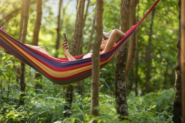 Tropikal yağmur ormanlarında akıllı telefon ile hamakta dinlendirici