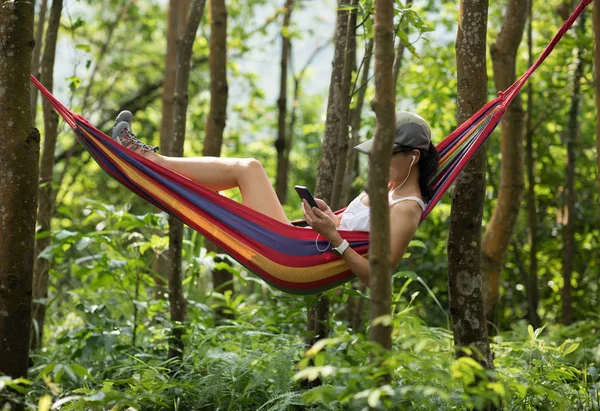ハンモックでリラックス 熱帯雨林でスマートフォンを使用 — ストック写真